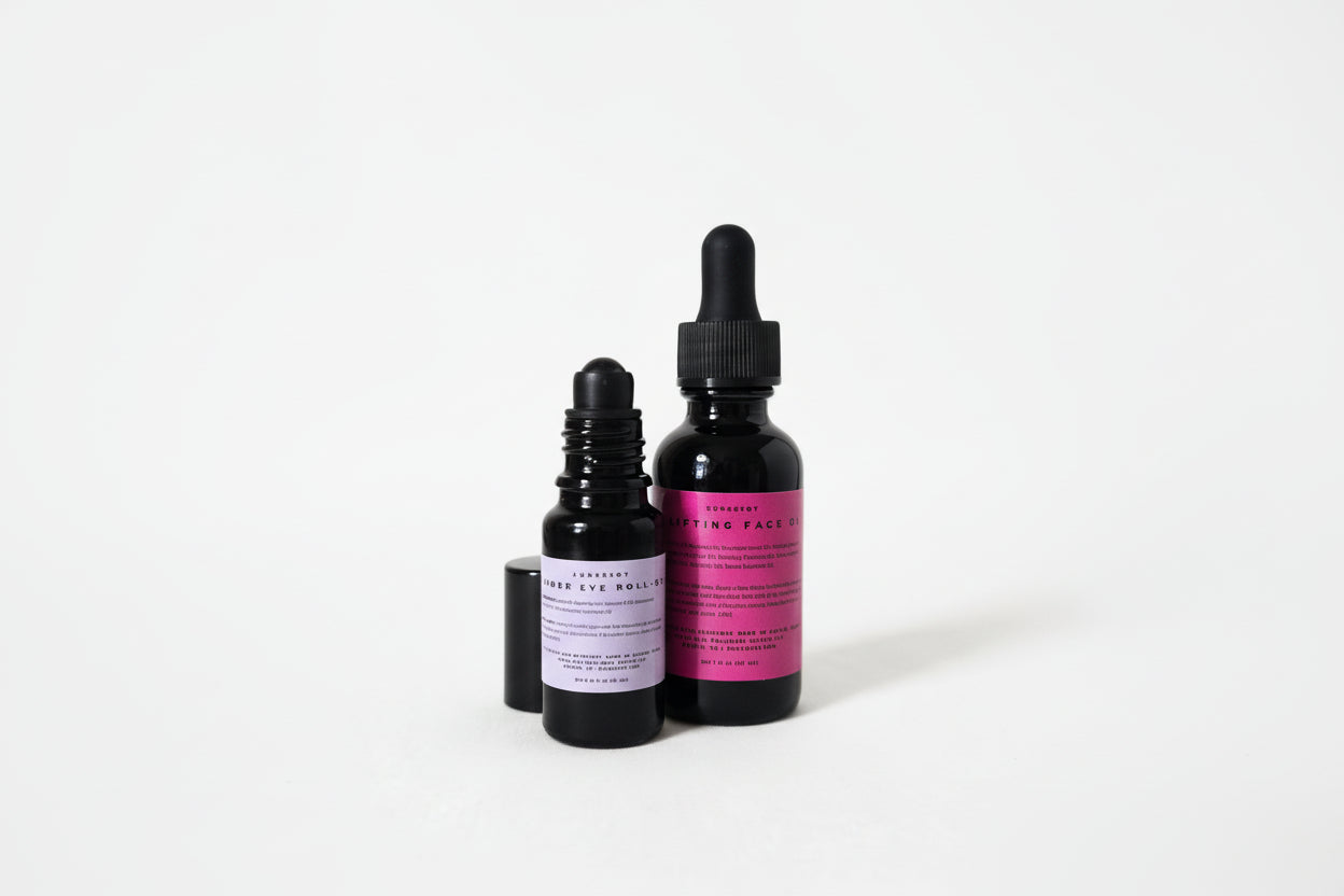 Two black dropper bottles with pink labels on a white background
