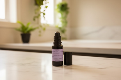 Black bottle with a purple label on a marble surface and warm light background