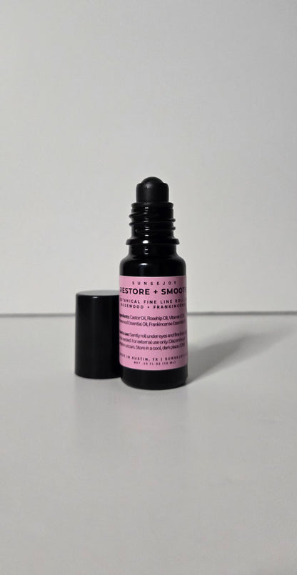 Black dropper bottle with pink label on a gray background