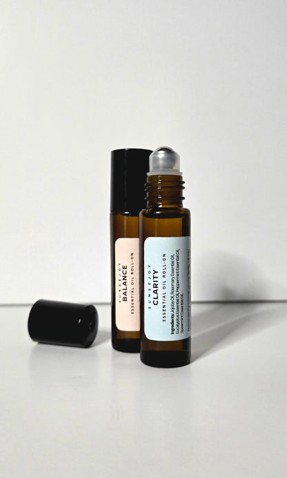 Two essential oil roller bottles labeled 'Balance' and 'Clarity' on a white background
