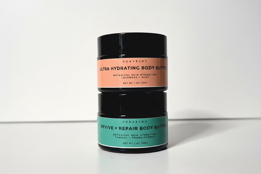 Two cylindrical containers of Ultra Hydrating Body Butter on a white background