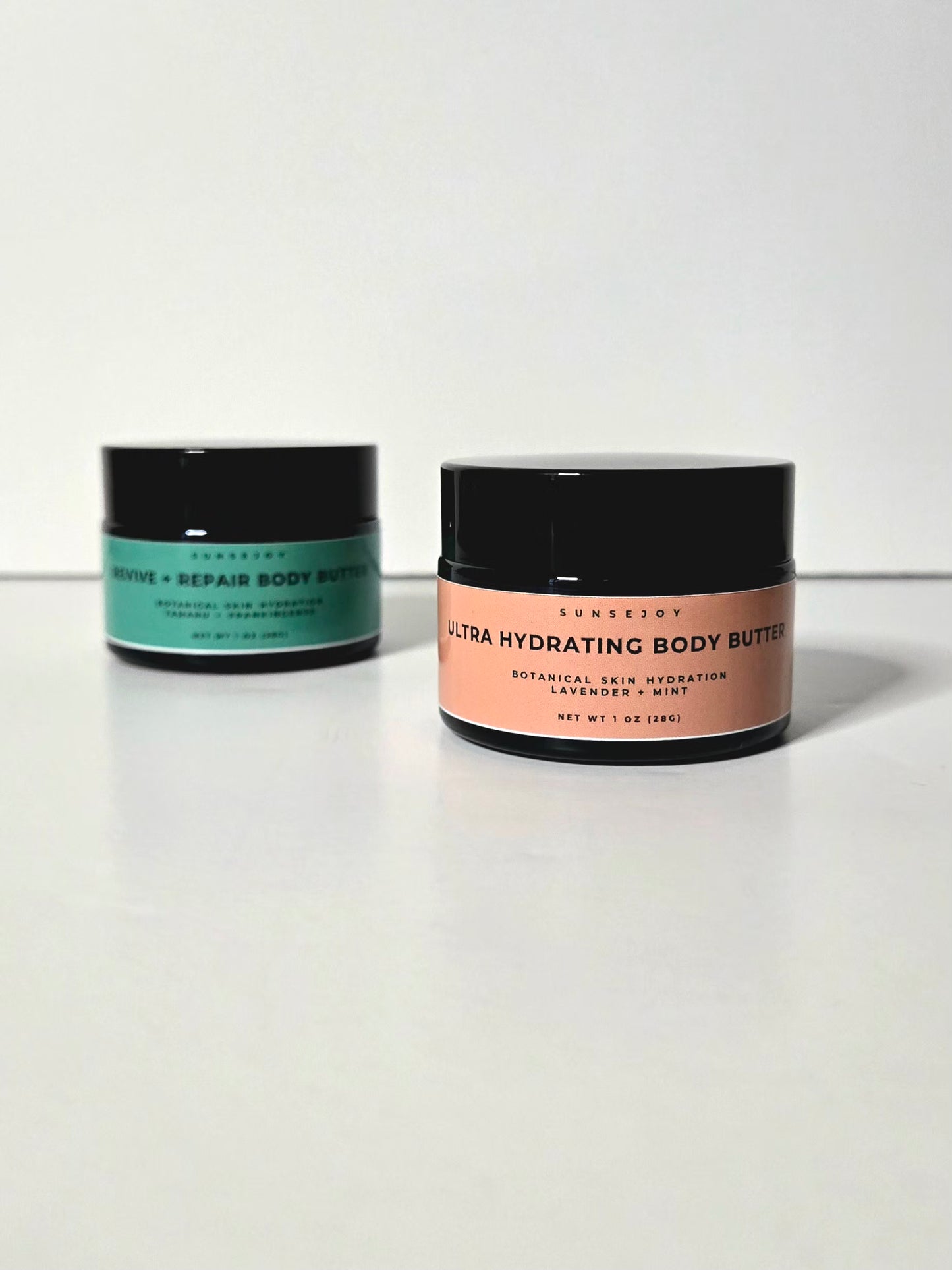 Two jars of ultra hydrating body butter on a white background