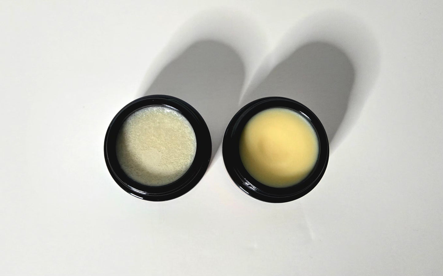 Two black containers with beige contents on a white background