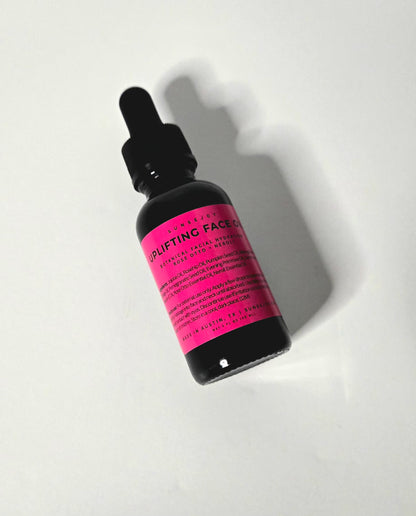 Skincare dropper bottle with pink label on a white background
