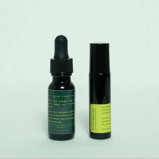 Two black bottles with green labels on a light gray background