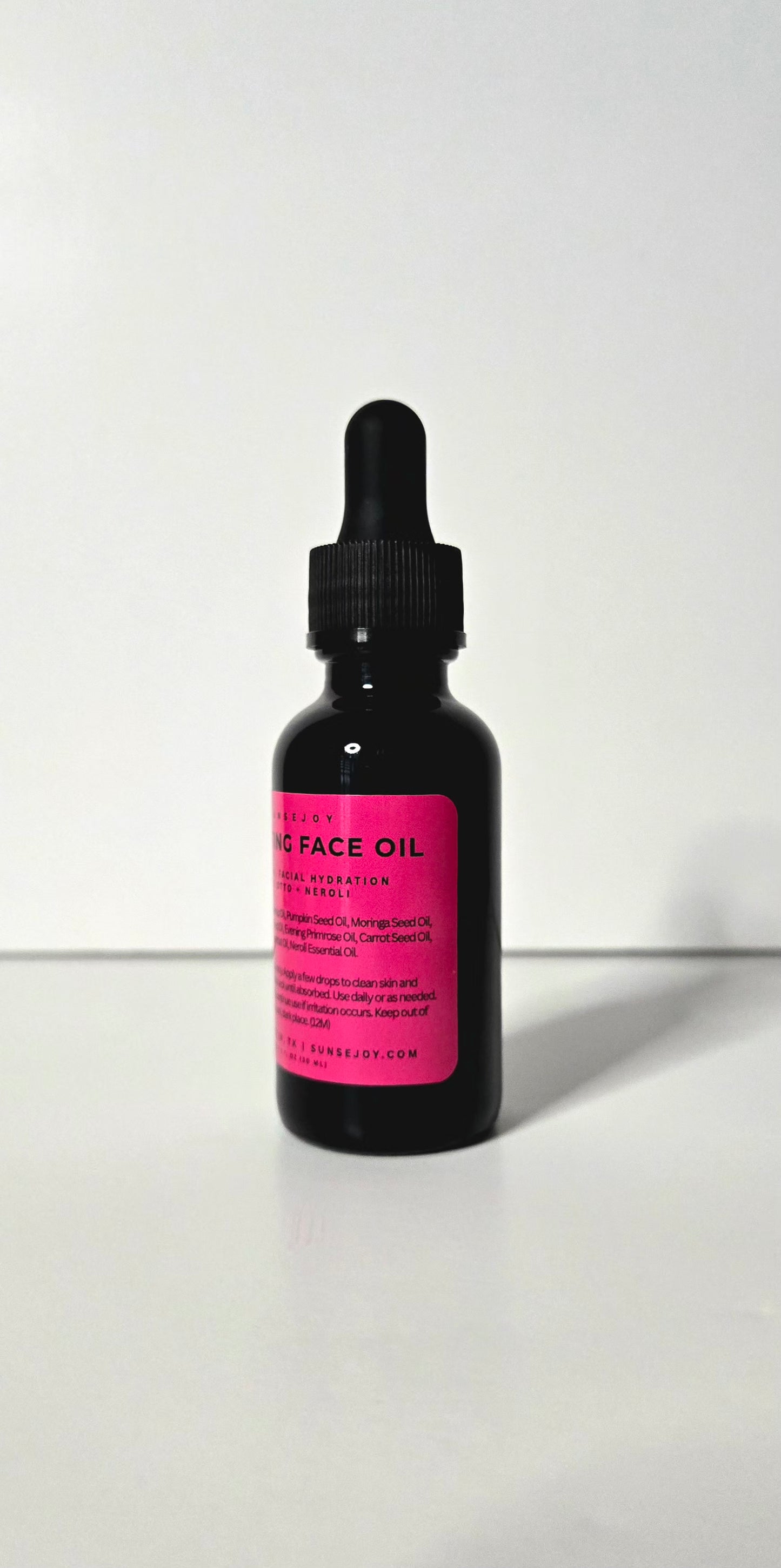 Black bottle with pink label on a white background